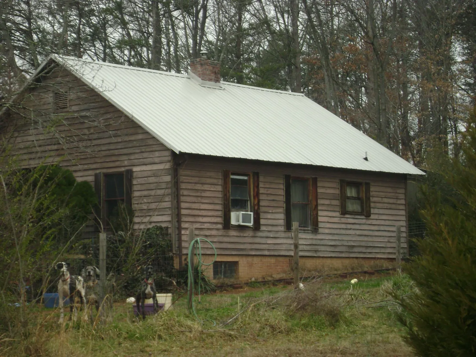 White metal roof on an old wood sided farmhouse, from a Metal Roof Installation job in Carrboro